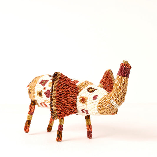 A handcrafted beaded elephant figurine, featuring intricate geometric beadwork in terracotta red, cream, tan, and brown on a solid white background.