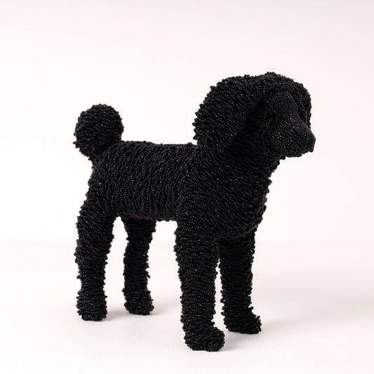 A black poodle-shaped decorative figurine made of beads, standing against a plain light background.