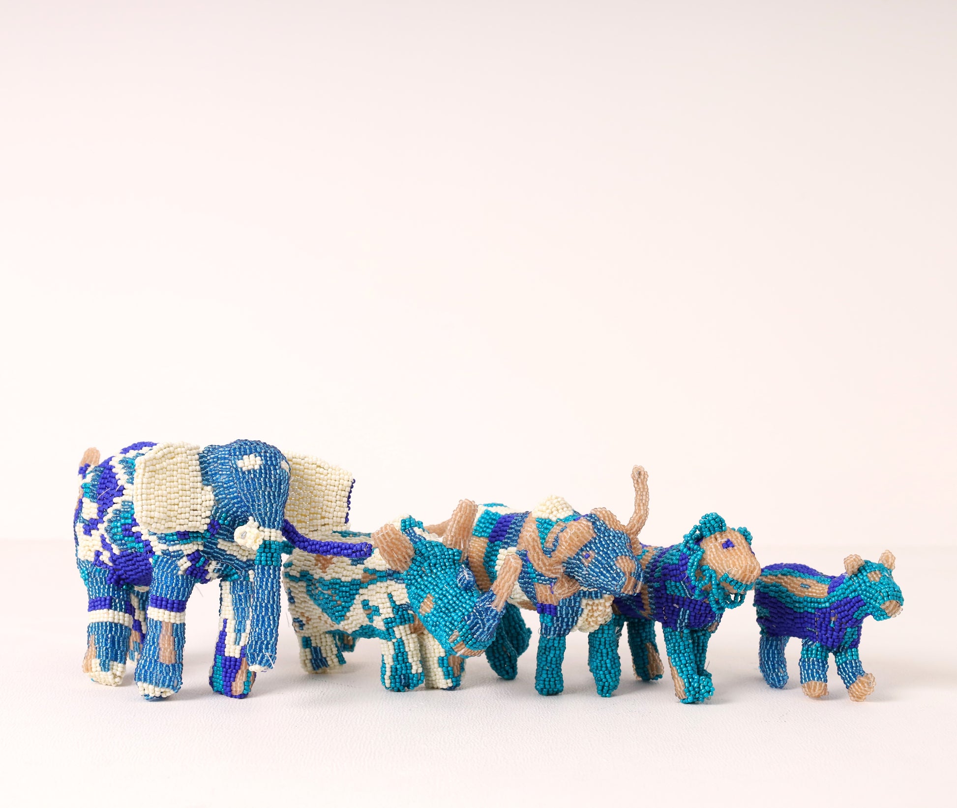 A handmade beaded big five sculpture, featuring blue, white and gray on a white background. 