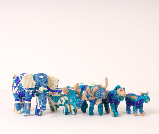 A handmade beaded big five sculpture, featuring blue, white and gray on a white background. 